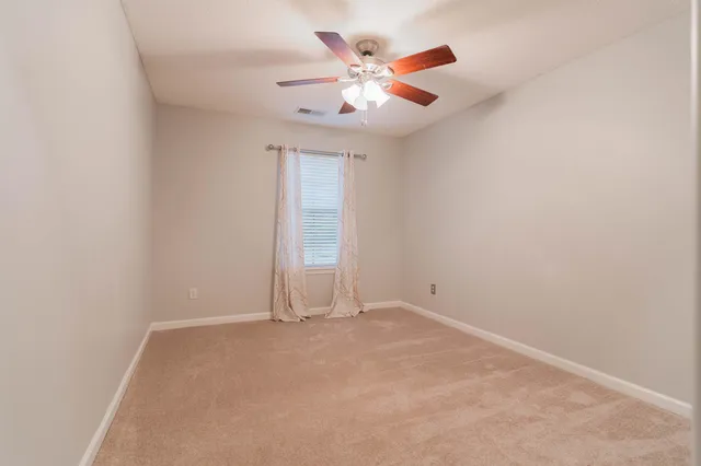 an empty room with closet and ceiling fan