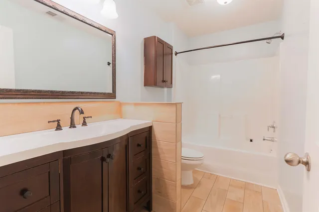 a bathroom with a granite countertop sink toilet and shower
