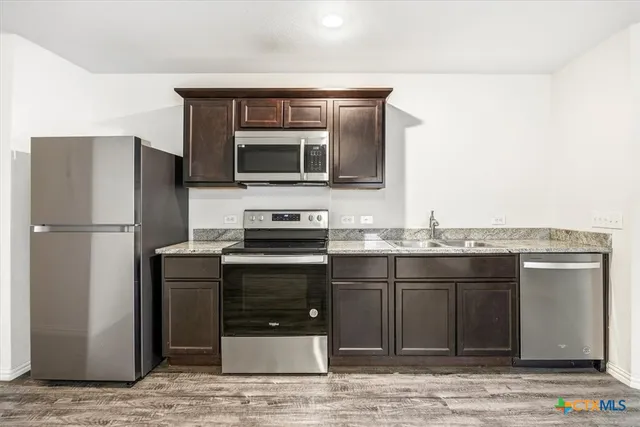 a kitchen with a sink and stainless steel appliances