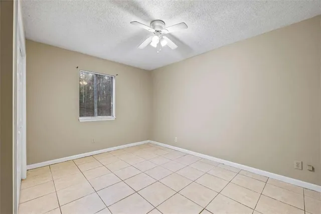 a view of an empty room and chandelier fan