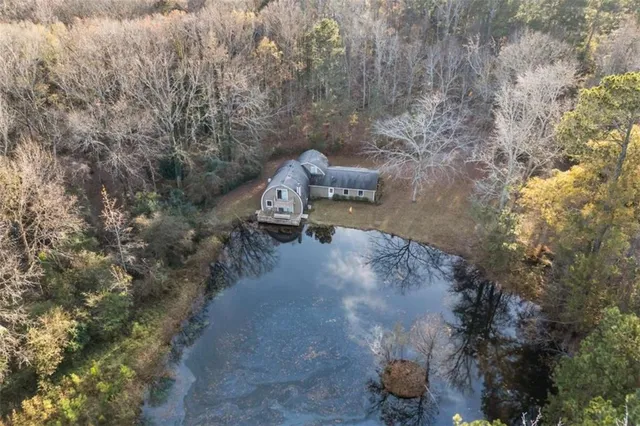 an aerial view of a house with a yard and large tree