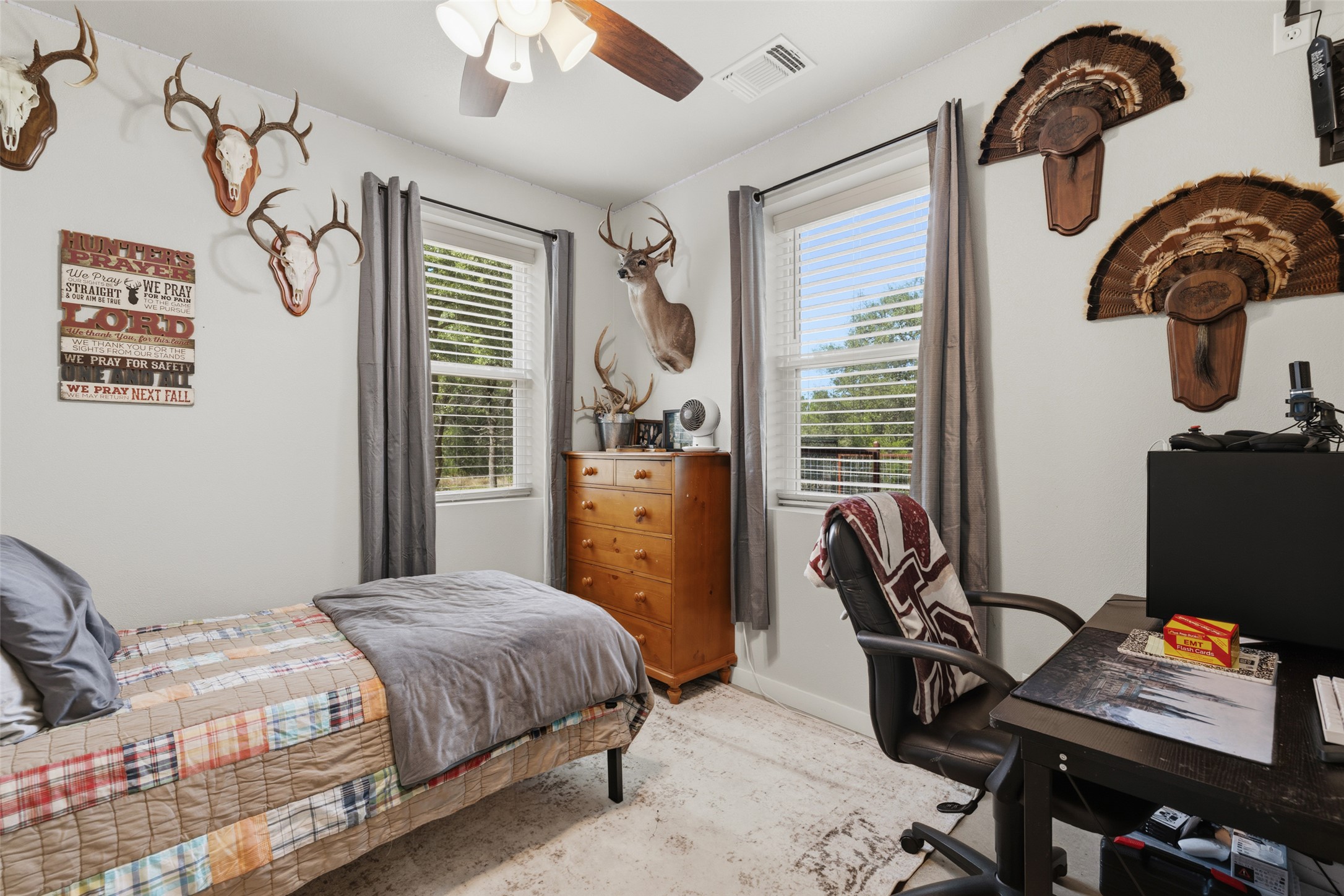764 Stubbs Road Johnson City, TX 78636 - Photo 27 of 29 A restful bedroom offers comfort and a well-lit space with a ceiling fan and natural views.