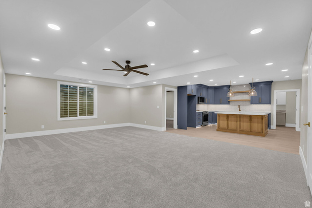 2828 Jojo Road Eagle Mountain, UT 84005 - Photo 39 of 63 Spacious open-concept living area featuring a tray ceiling with recessed lighting and a ceiling fan