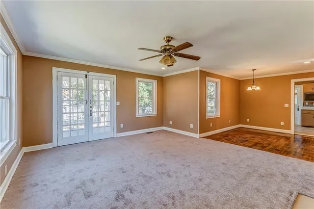 an empty room with a fireplace and a ceiling fan