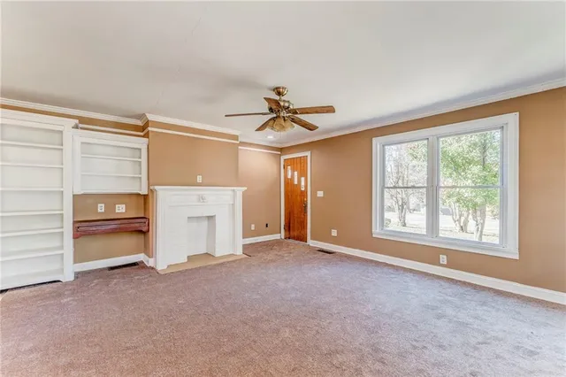 a view of a livingroom with a ceiling fan and window