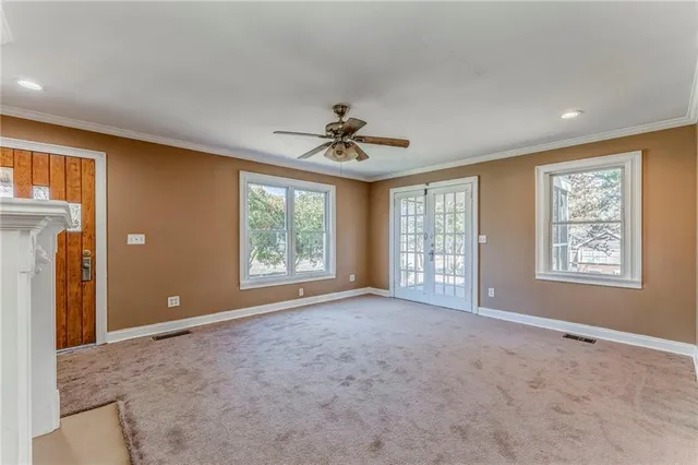 a view of an empty room with a fireplace and a window