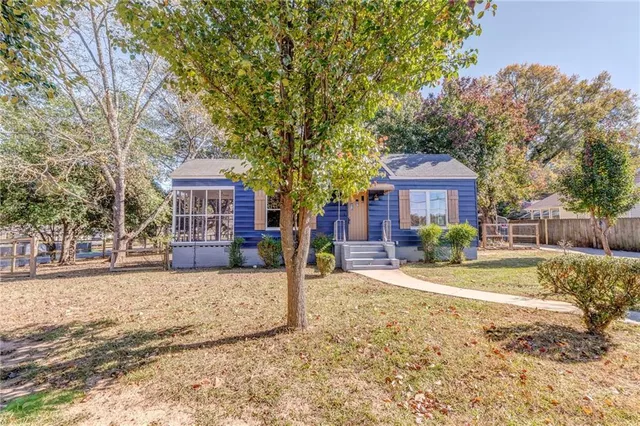 a front view of a house with yard tree and wooden fence