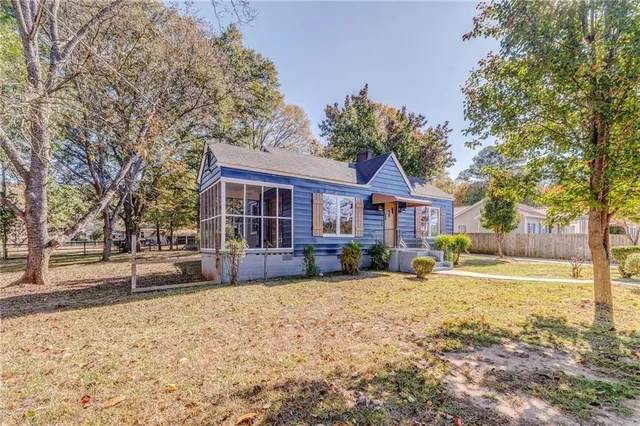 a view of backyard with small cabin and wooden fence