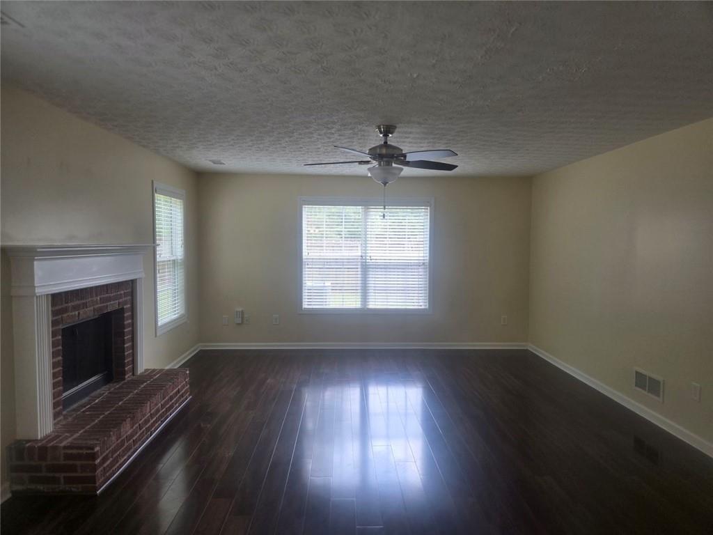 22 Windcrest Keep Covington, GA 30016 - Photo 7 of 32 an empty room with wooden floor fireplace and windows