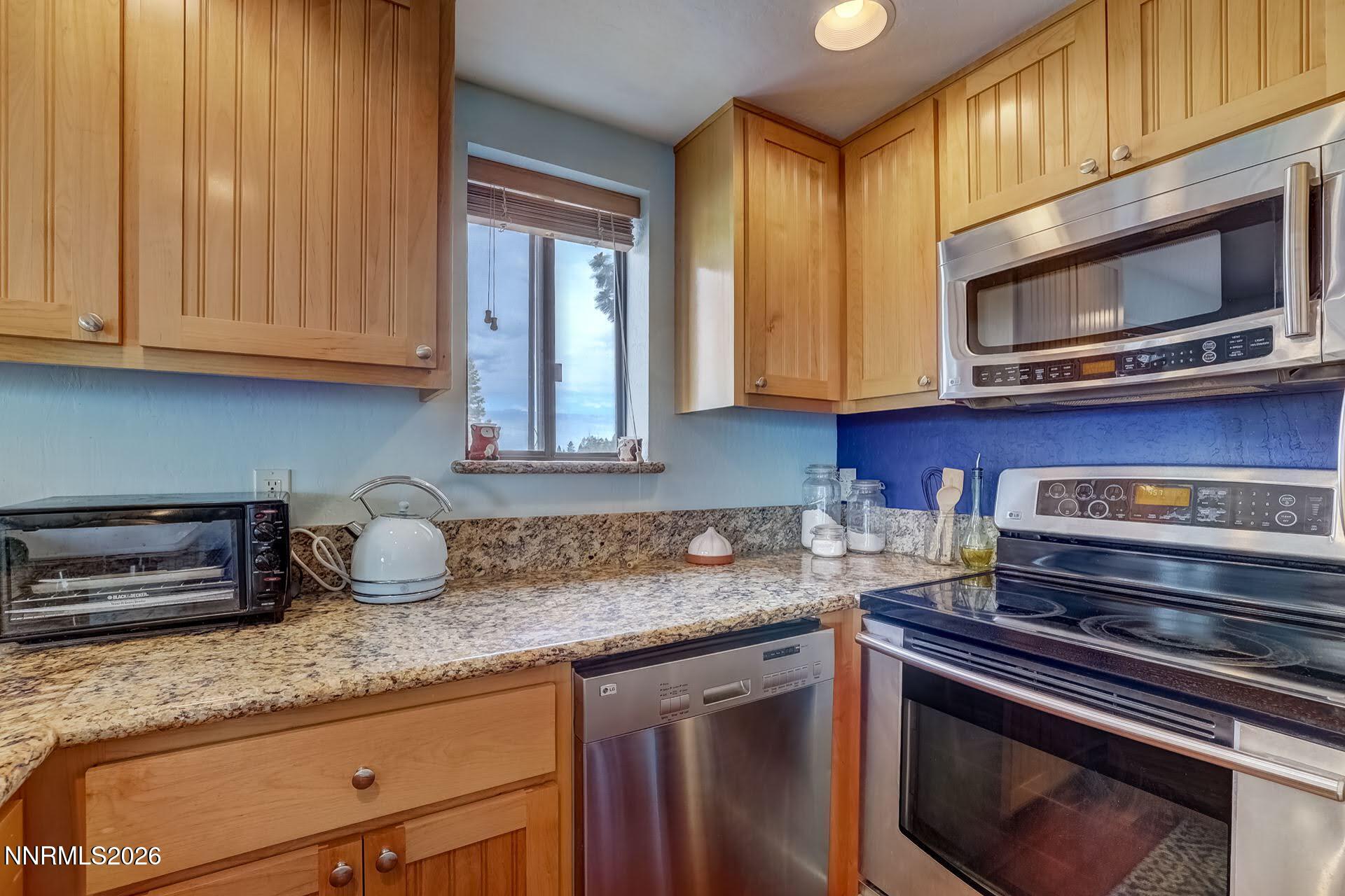 495 Tramway Drive, Unit 7 Stateline, NV 89449 - Photo 11 of 31 a kitchen with stainless steel appliances granite countertop a sink stove and microwave