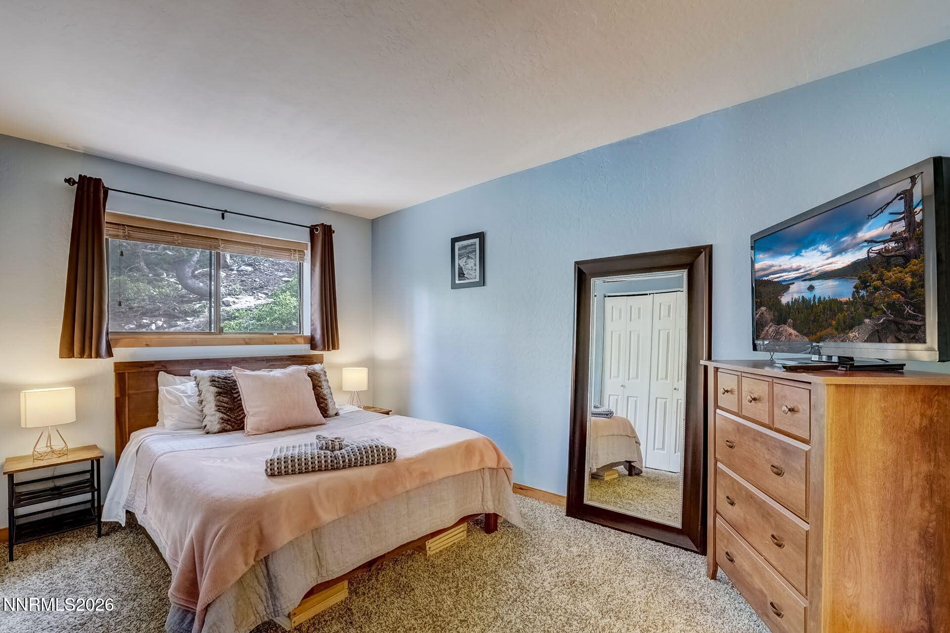 495 Tramway Drive, Unit 7 Stateline, NV 89449 - Photo 13 of 31 a bedroom with a bed and a flat tv screen on dresser