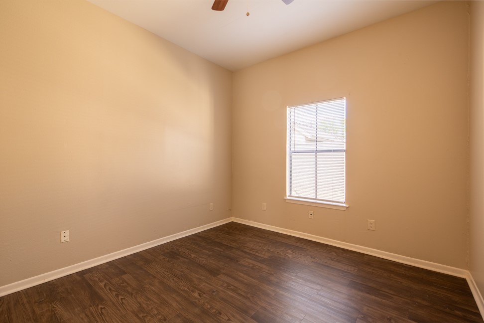 712 Graham Place, Unit 305 Austin, TX 78705 - Photo 14 of 18 Spare room featuring dark wood-type flooring and ceiling fan
