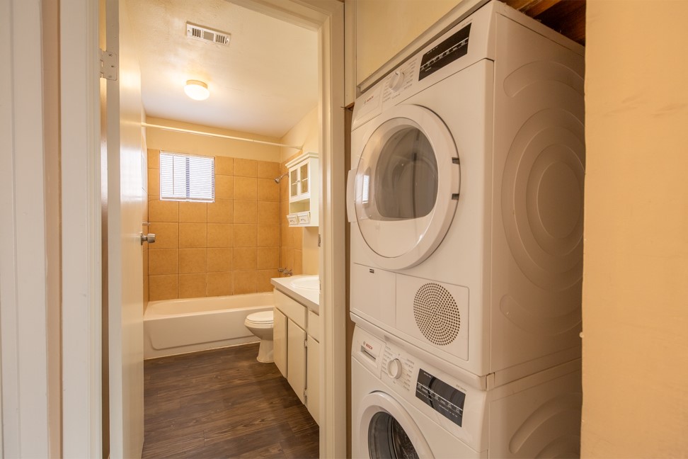 712 Graham Place, Unit 305 Austin, TX 78705 - Photo 17 of 18 Laundry area with stacked washer and clothes dryer and dark wood-style floors