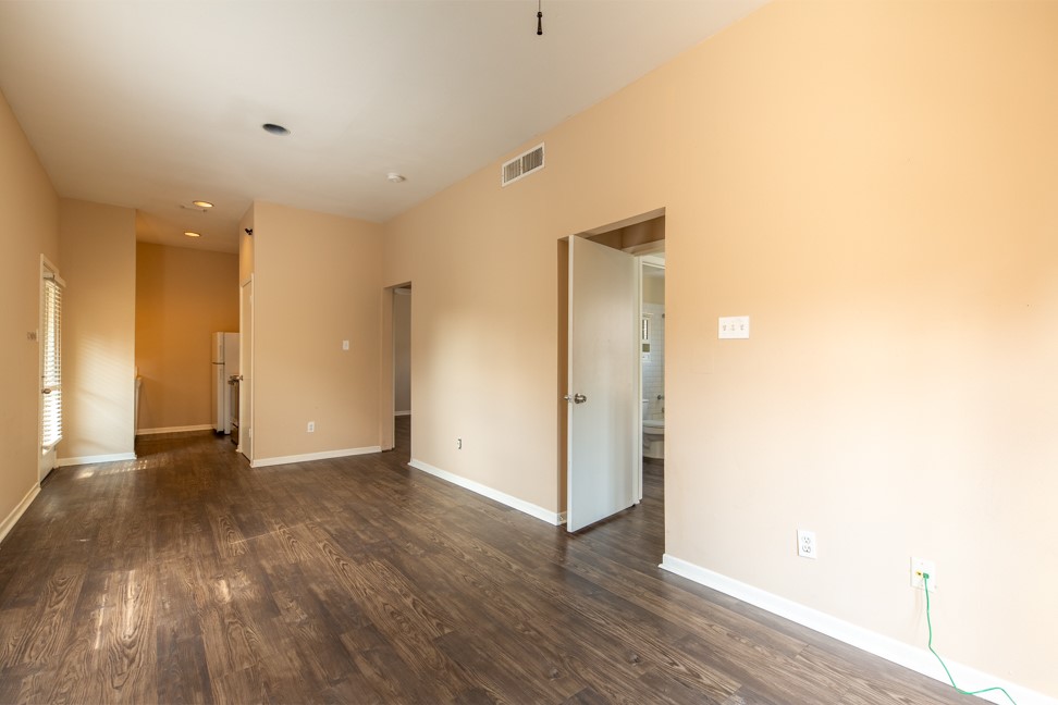 712 Graham Place, Unit 305 Austin, TX 78705 - Photo 6 of 18 Empty room with dark wood-type flooring and baseboards
