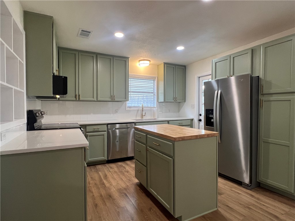 Undisclosed Address Corpus Christi, TX 78418 - Photo 8 of 20 a kitchen with a refrigerator a microwave a sink and a stove with wooden floor