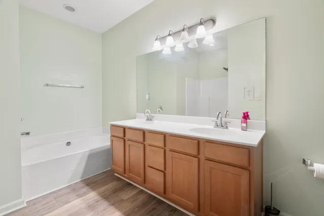 a bathroom with a tub sink and mirror