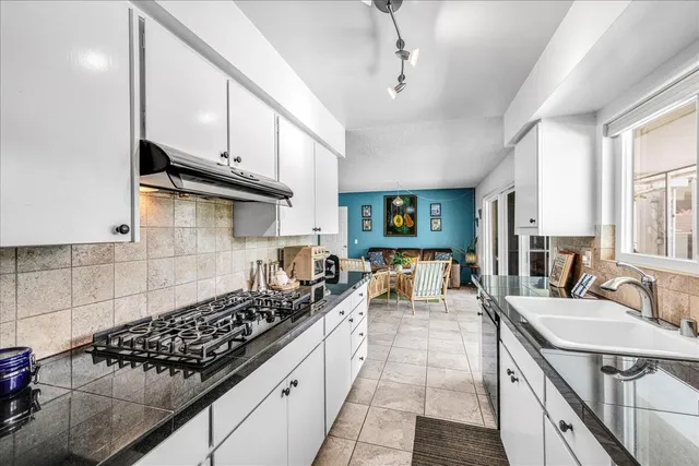 a kitchen with stainless steel appliances granite countertop a sink stove and cabinets