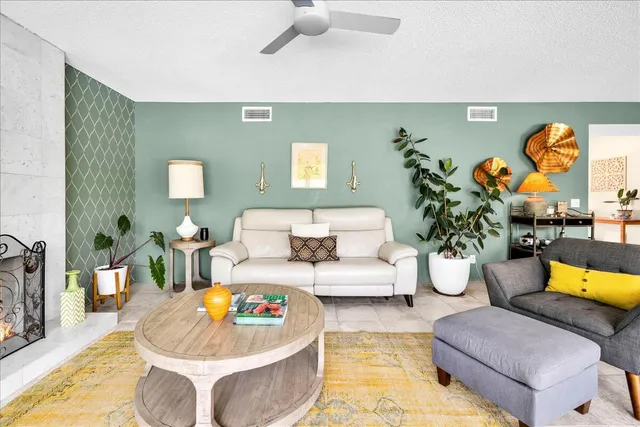 a living room with patio furniture and a garden