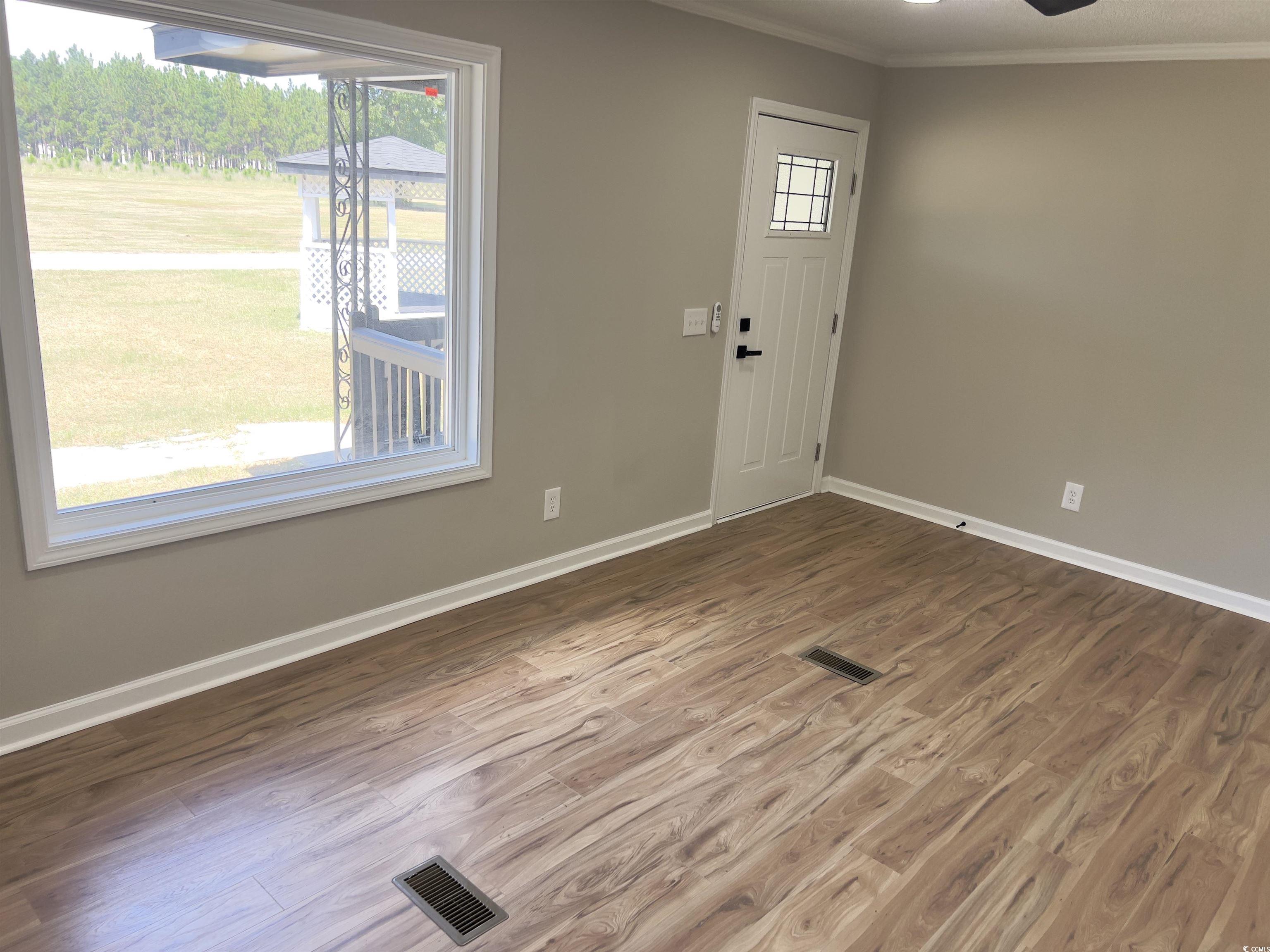 342 Lee Street Scranton, SC 29591 - Photo 5 of 22 Foyer entrance with wood finished floors, ornamental molding, and a ceiling fan