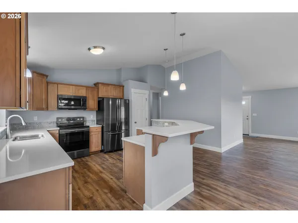 a kitchen with a sink a counter space and wooden floor