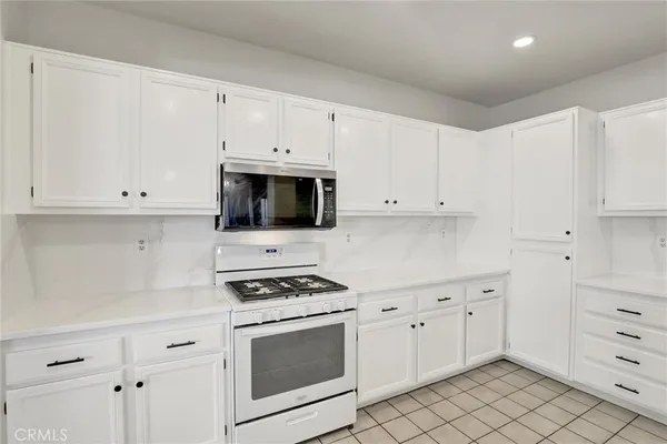 a kitchen with white cabinets and appliances