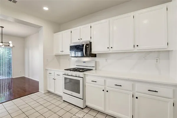 a kitchen with white cabinets and white appliances