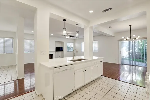 a large white kitchen with a sink and cabinets