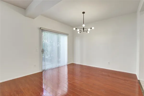 a view of wooden floor and chandelier in living room