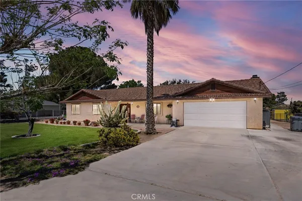 a front view of a house with yard and garage