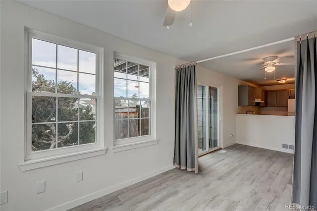 an empty room with wooden floor and windows