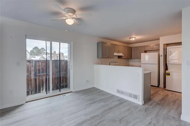 a kitchen view with wooden floor and a refrigerator