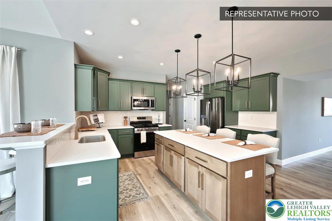 2010 Settlers Ridge Road, Unit LOT 4 Slatington, PA 18080 - Photo 10 of 20 a kitchen that has a sink a microwave oven a sink and a dining table with wooden floor