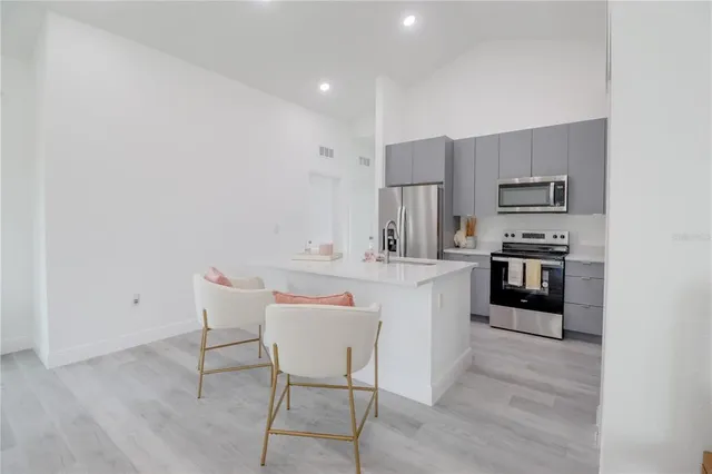 a kitchen with stainless steel appliances kitchen island granite countertop a sink and cabinets