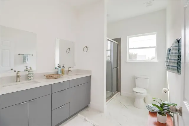 a spacious bathroom with a granite countertop sink a toilet and a mirror