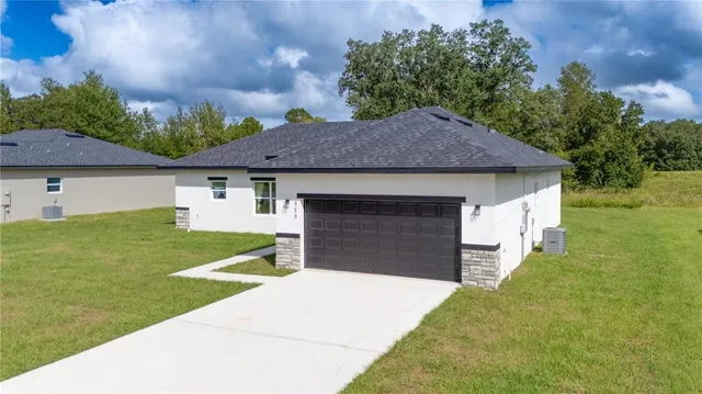 a front view of a house with a garden and yard
