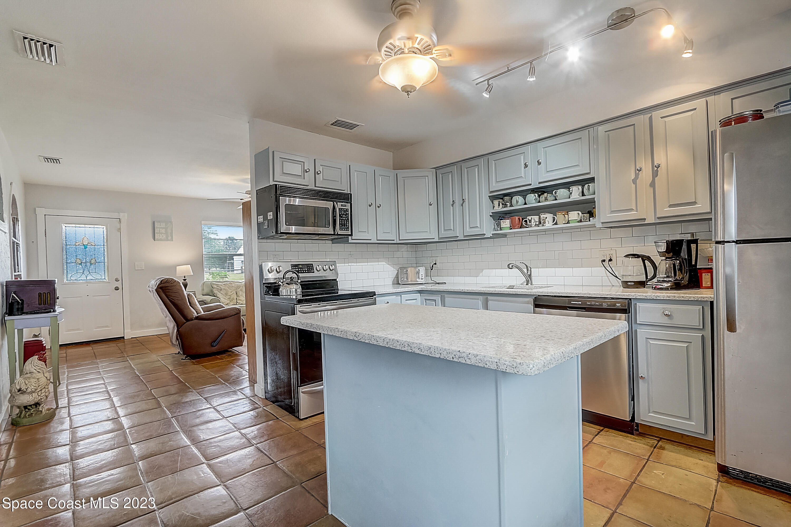 201 Cherry Street Melbourne, FL 32901 - Photo 7 of 22 a kitchen with stainless steel appliances granite countertop a sink refrigerator and cabinets