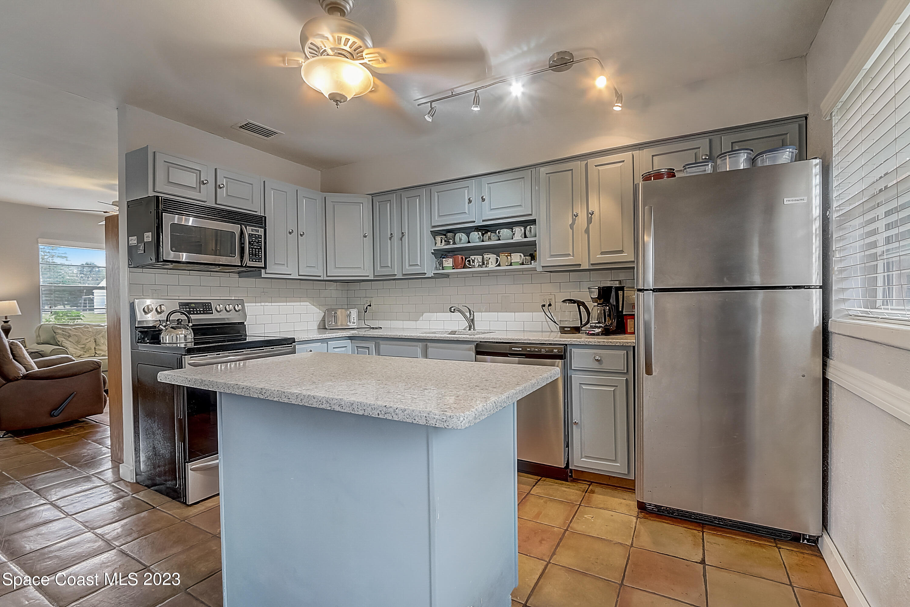 201 Cherry Street Melbourne, FL 32901 - Photo 8 of 22 a kitchen with stainless steel appliances granite countertop a refrigerator a sink a stove a microwave oven and a refrigerator with wooden cabinets