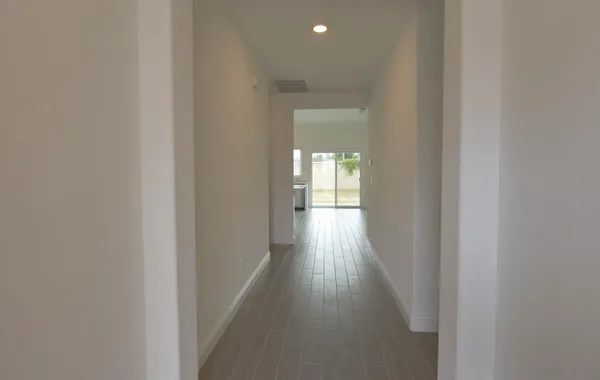a view of a hallway with wooden floor
