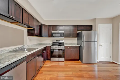 a kitchen with stainless steel appliances granite countertop a refrigerator stove a sink and a microwave