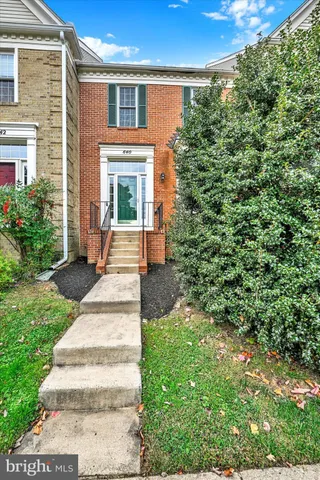 a front view of a house with a yard and trees