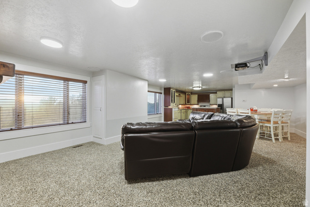 2342 Charros Road Sandy, UT 84092 - Photo 50 of 94 Open-concept living space featuring neutral carpet flooring, recessed lighting, and a large window with horizontal blinds