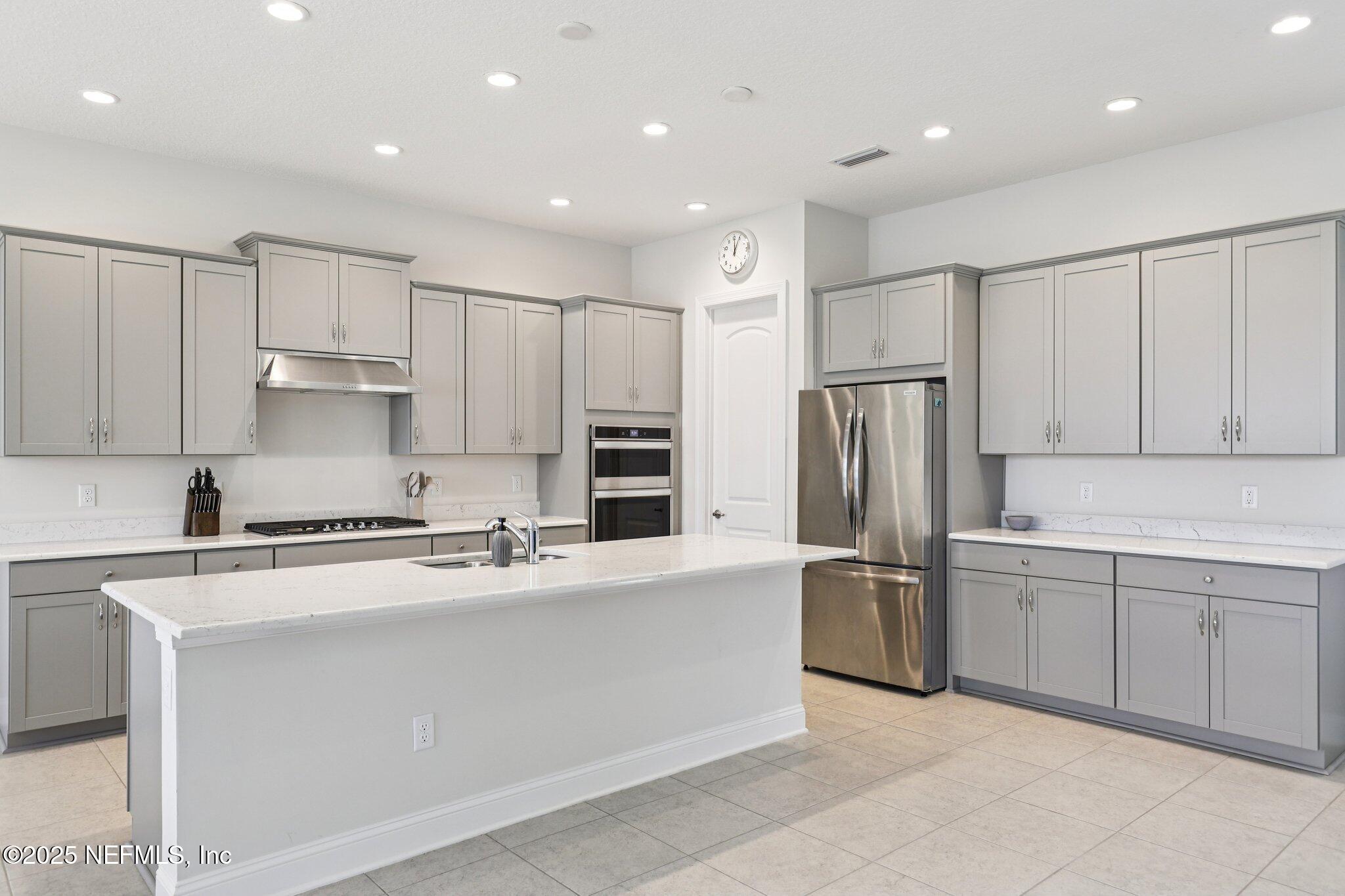 194 Snowbell Court St. Augustine, FL 32095 - Photo 12 of 89 a kitchen with stainless steel appliances granite countertop a refrigerator sink and cabinets