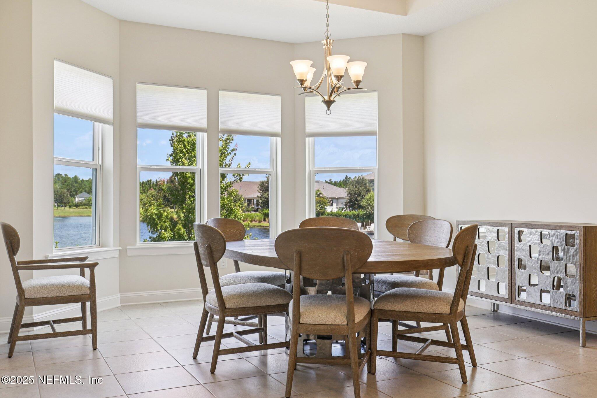 194 Snowbell Court St. Augustine, FL 32095 - Photo 16 of 89 a view of a dining room with furniture a chandelier and large windows