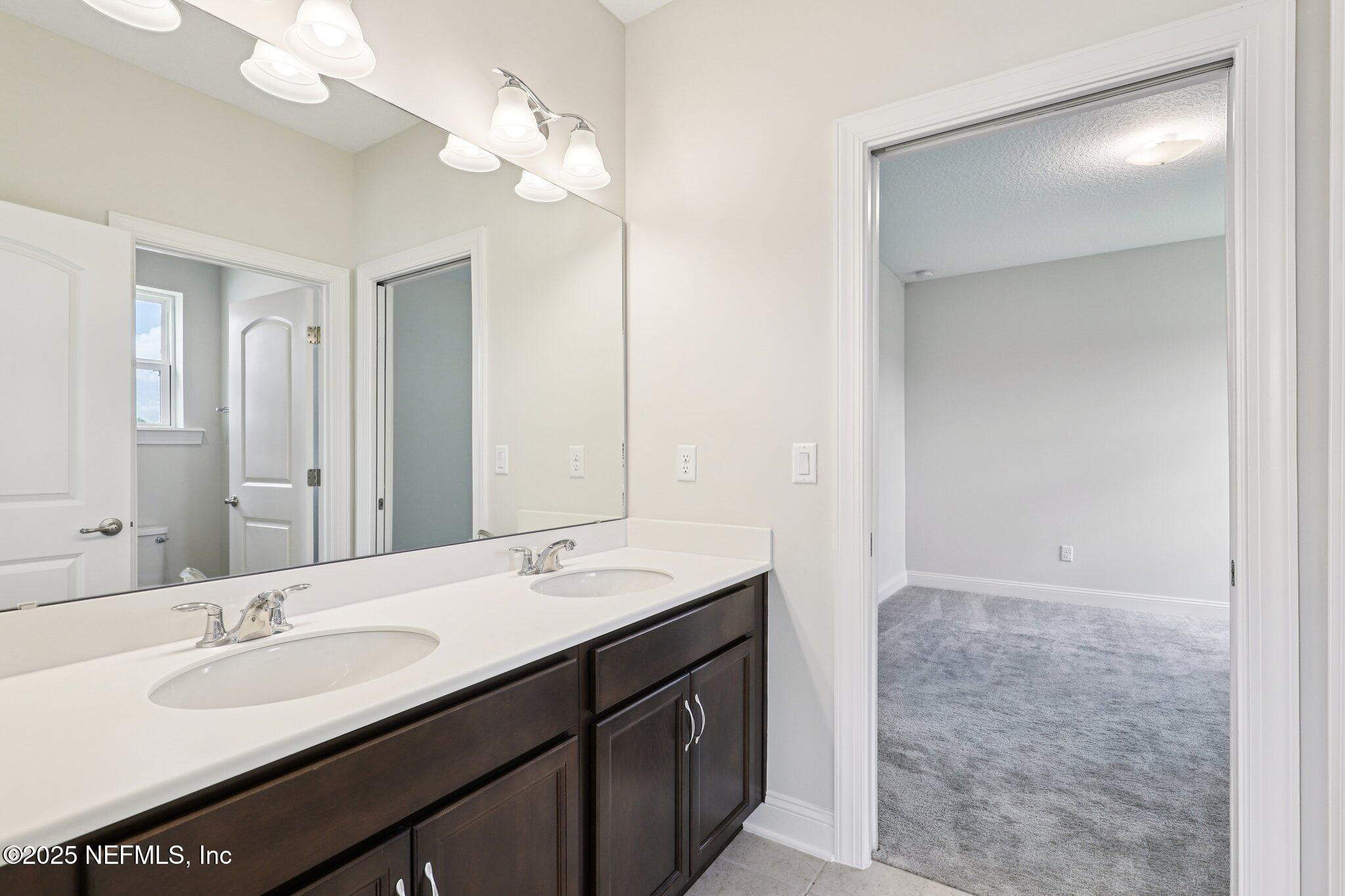 194 Snowbell Court St. Augustine, FL 32095 - Photo 45 of 89 a bathroom with a double vanity sink a and a mirror