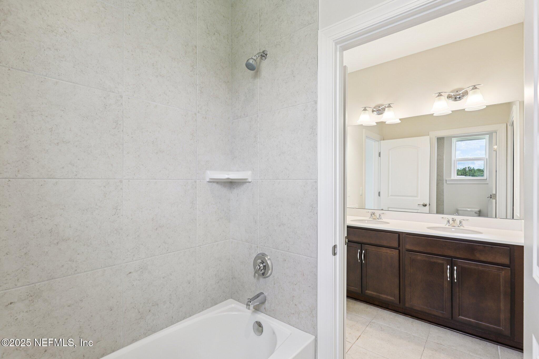 194 Snowbell Court St. Augustine, FL 32095 - Photo 46 of 89 a bathroom with a tub sink and mirror
