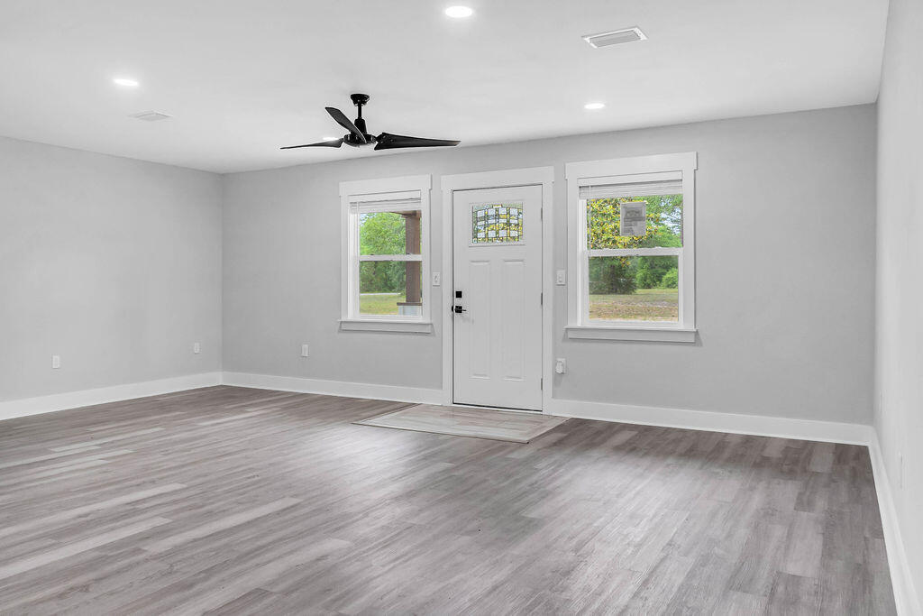 5742 Mt Olive Road Crestview, FL 32539 - Photo 11 of 59 an empty room with wooden floor and windows