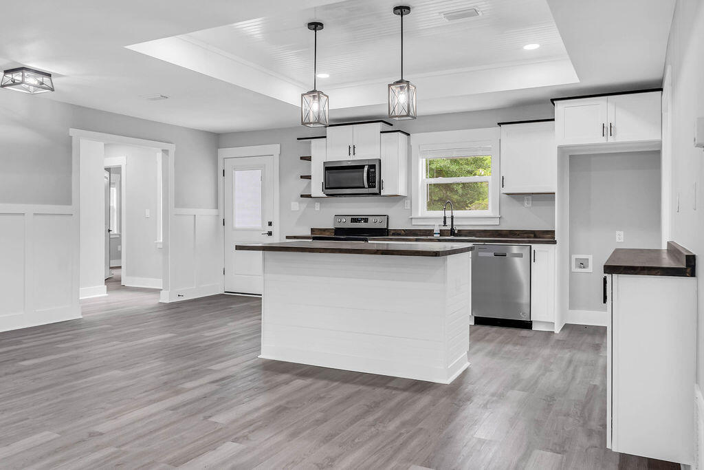 5742 Mt Olive Road Crestview, FL 32539 - Photo 3 of 59 a kitchen with stainless steel appliances granite countertop a sink a stove a refrigerator and island with wooden floor
