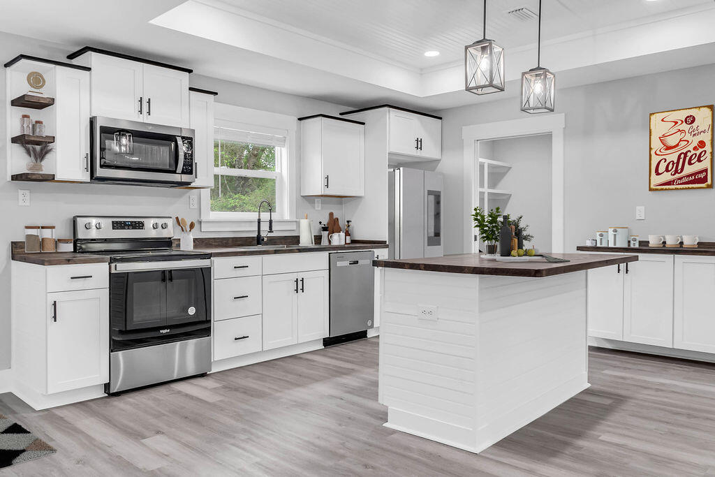 5742 Mt Olive Road Crestview, FL 32539 - Photo 4 of 59 a kitchen with stainless steel appliances granite countertop a sink a stove a refrigerator cabinets and wooden floor