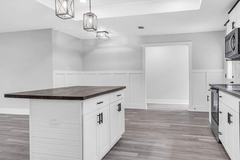 5742 Mt Olive Road Crestview, FL 32539 - Photo 7 of 59 a kitchen with stainless steel appliances a stove and wooden floor