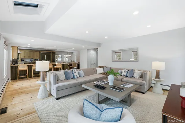 a view of a dining room and livingroom with furniture wooden floor a chandelier